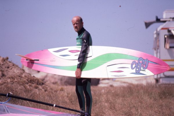 Oldschool picture of a men holding his windsurfing board
