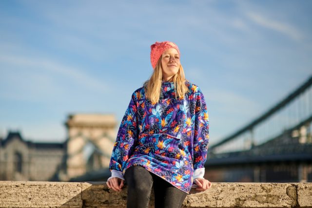 Surf girl in Budapest enjoying sunshine in oversized flower hoodie.