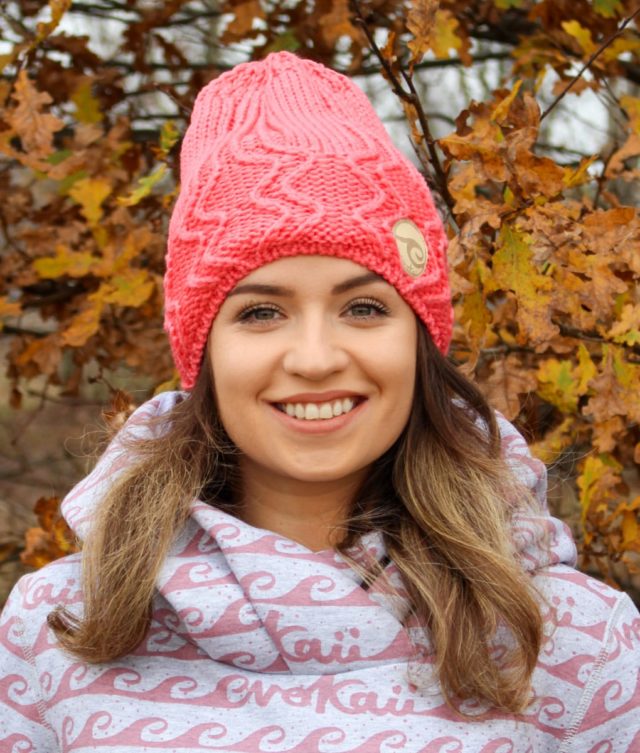 Surf girl beanie hat knitted with polar inside standing in the autumn forest.