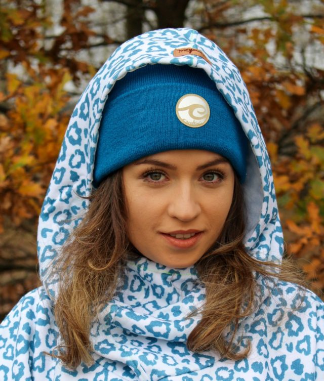 Surf beanie deep ocean worn by surf girl in autumn forest with panthera surf hoodie outfit.