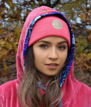 Surf beanie in salmon colour in autumn forest worn by surf girl.